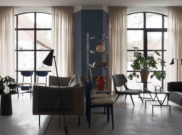 Living room featuring designer furniture with two large windows flooding the space with abundant natural light