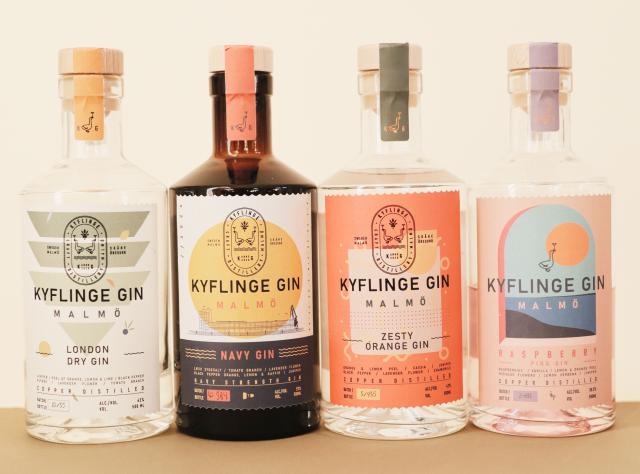 Four Kyflinge Gin bottles from Malmö with wooden stoppers, featuring London Dry, Navy Gin, Zesty Orange, and Raspberry Pink varieties with distinct label designs