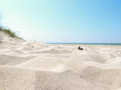 En vit sandstrand i Sandahmmar på en klar sommardag