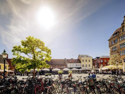 Der Platz Lilla Torg in Malmö, wo an einem sonnigen Sommertag viele Fahrräder nebeneinander geparkt sind.
