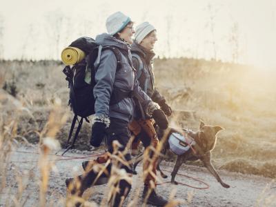 Två personer på vandring med hund