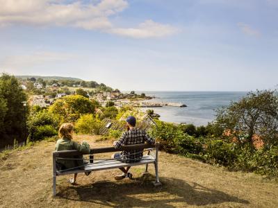 Couple on a bench ovelooking a village by the sea